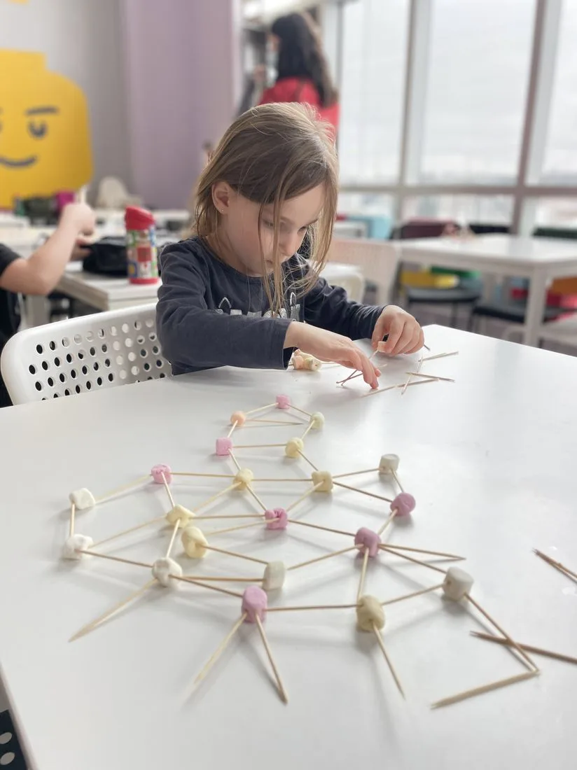 A young student building a marshmallow-and-toothpick structure