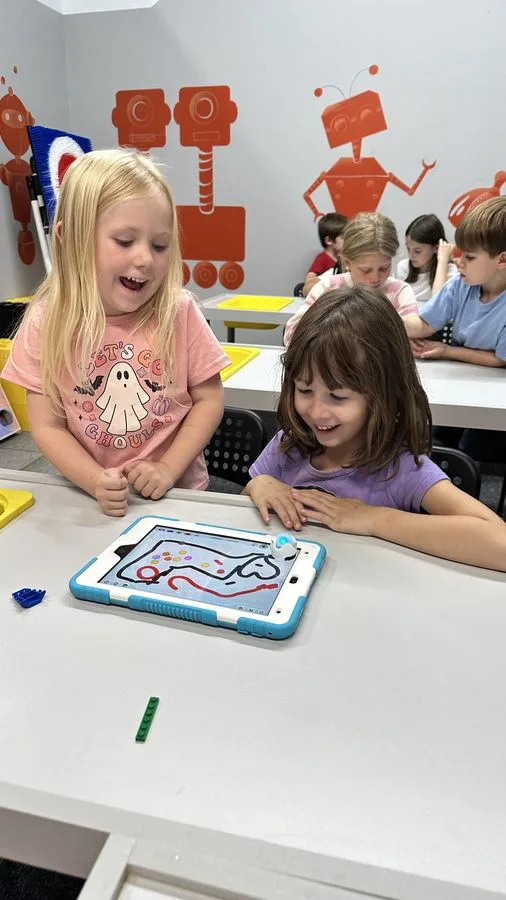 Two students coding an Ozobot robot on a tablet