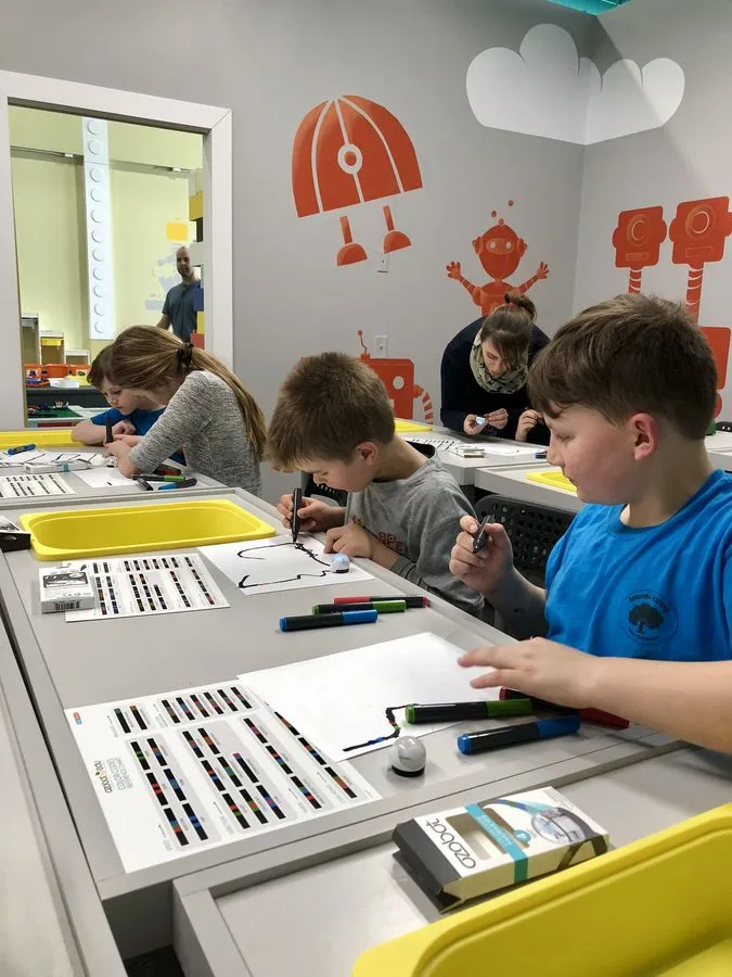 Students building and coding with Ozobot robots at their desks
